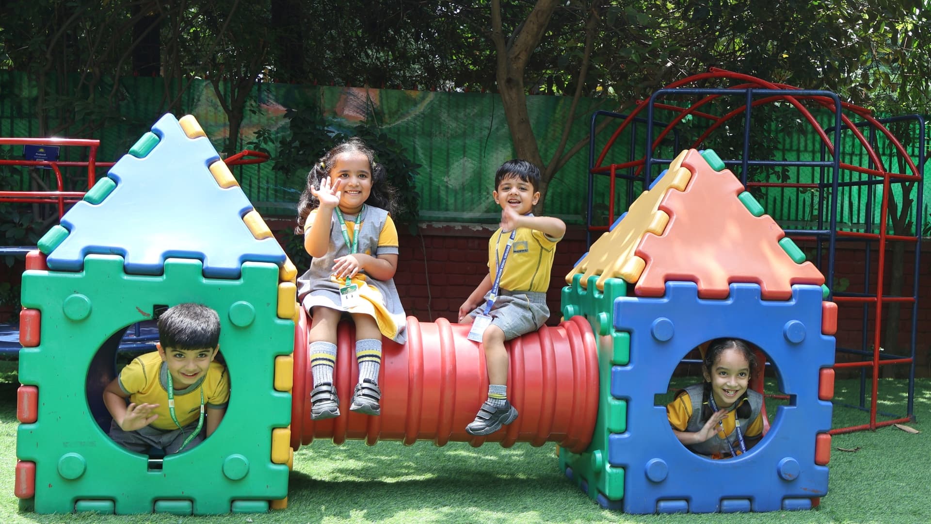 Children waving and playing on the outdoor play equipment